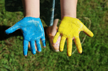 hands painted in the color of the Ukrainian flag child yellow-blue color