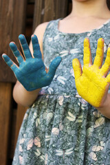 hands painted in the color of the Ukrainian flag child yellow-blue color
