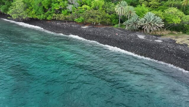 Aerial Captain Cook Bay black lava beach woman Kona Hawaii. Blue Pacific ocean water. Snorkel scuba dive  vacation destination. Black volcanic lava rock. Recreation relaxation. Tropical destination.