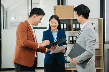 Fototapeta premium Mid age Asian business woman ceo executive manager showing to colleagues team income revenue data figures planning on big screen in modern office.