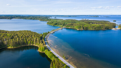 Road leading through the finnish lake district, seen from the air on a beautiful summer day - obrazy, fototapety, plakaty