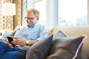 Mature, phone or happy man on social media with internet connection or website notification on sofa. House, search or senior person texting on networking mobile app chat or reading news to relax