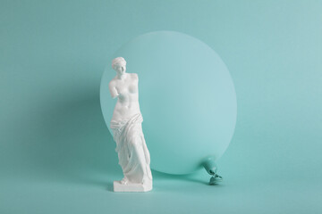 a Venus de Milo in front of a turquoise balloon in the same color as the background.
