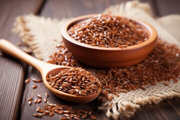flax seeds in a wooden spoon on wooden table - obrazy, fototapety, plakaty
