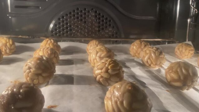Several panellets of pine nuts browning in the oven. Typical snack eaten on the feast of All Saints in Catalonia. 