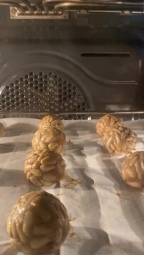 Several panellets of pine nuts browning in the oven. Typical snack eaten on the feast of All Saints in Catalonia. 