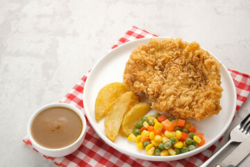 Crispy Chicken Steak with french fries and vegetables. 

