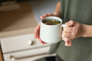a cup of herbal tea is held in hands