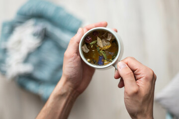a cup of herbal tea is held in hands