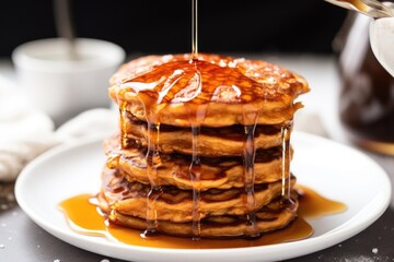 vegan sweet potato pancakes with maple syrup dripping down the side