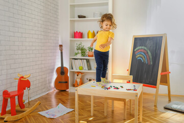 Young girl standing on the table and have a fun. Play and learning concept. - obrazy, fototapety, plakaty