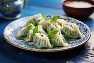 steamed dumplings with a sprig of mint on a blue patterned plate