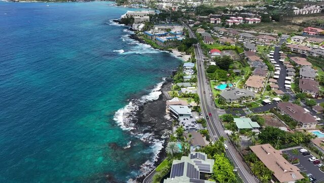 Aerial ocean coastal hotel resorts Kona Hawaii fast. Big Island. Luxury resorts, townhouses and homes on coast tropical landscape. Volcanic lava  environment. Economy is tourism based. Beach.