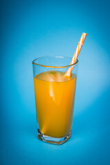 glass of orange juice on the blue background