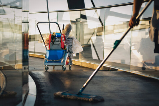 Reinigungskraft mit Arbeitsmitteln putzt