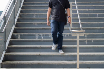 Cropped image of man walking down stairs. Exit subway. Passengers go down stairs from subway. - Powered by Adobe