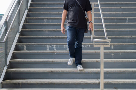 Cropped image of man walking down stairs. Exit subway. Passengers go down stairs from subway.