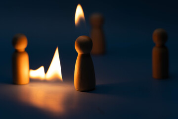 The wooden figure, isolated from the crowd with a fire, being chased away due to confusion and...