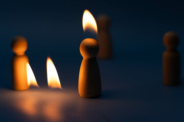 The wooden figure, isolated from the crowd with a fire, being chased away due to confusion and...