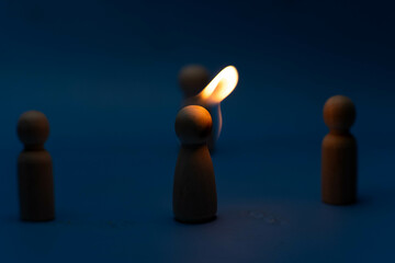 The wooden figure, isolated from the crowd with a fire, being chased away due to confusion and...