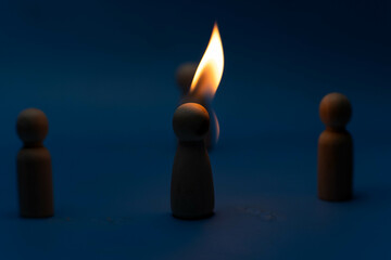 The wooden figure, isolated from the crowd with a fire, being chased away due to confusion and...