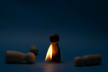 The wooden figure, isolated from the crowd with a fire, being chased away due to confusion and...