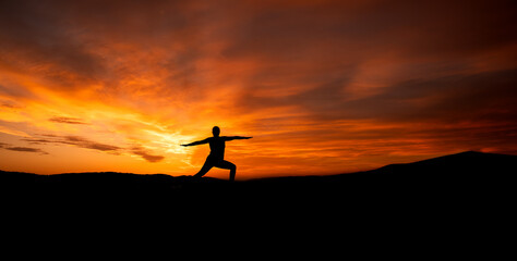 Kobieta ćwicząca joge na plaży na tle zachodu słońca, woman practicing yoga - obrazy, fototapety, plakaty