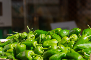 Closeup of green peppers neatly stacked at a market, ready for sale