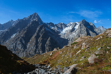 Fototapeta na wymiar The panorama of Val Ferret, one of the wildest and most spectacular areas of the Italian Alps, near the town of Courmayeur, Valle d'Aosta, Italy - October 2, 2023.
