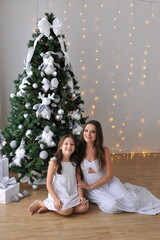 mãe e filha juntas em demonstração de afeto alegria e amor familiar, juntas  em frente  a arvore...