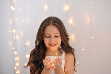 menina feliz sorridente  com luzes de natal 