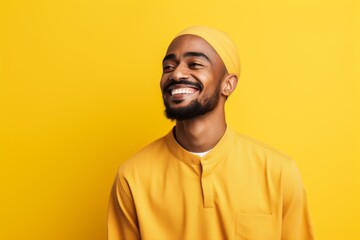 Fototapeta premium Portrait of a happy mulsim man laughing over yellow background