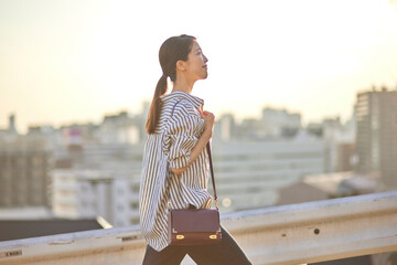 夕暮れの町並みと帰宅中の日本人女性