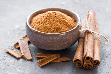 Cinnamon sticks and cinnamon powder on rustic background, healthy spice, (Cinnamomum)