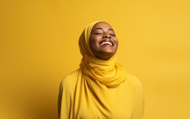 Confident African American Muslim woman in a stylish hijab, isolated on a vibrant yellow background