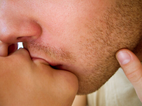 Closeup, love and man with woman in kiss, desire and lips together with touch on face. Couple, intimate and relationship for passion on mouth, romance and caring partner with bonding or quality time