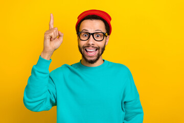 Photo of astonished smart man wear teal sweatshirt red beanie hat raising finger up have new idea...