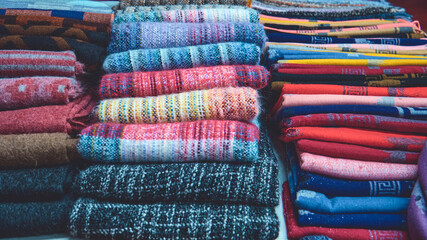 Stacked Peruvian ponchos at a street market. Natural alpaca wool in Chinchero near Cuzco in Peru