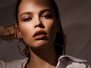 Portrait of a lovely girl model, creative light. Evening makeup and jewelry for the holiday....