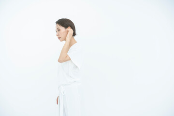 女性が髪を耳にかけている/白背景スタジオ撮影/