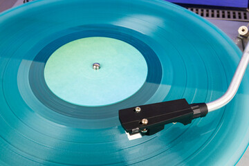 Close up of vintage turntable record player with turquoise vinyl