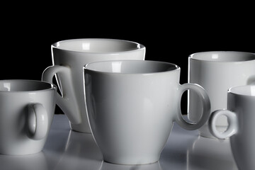 White porcelain cups isolated on black background. Blank, copycspace. Studio shot