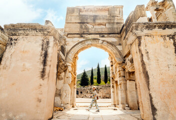 Tourist (woman) in the ancient city of Ephesus in Turkey with historic ruins in the background.