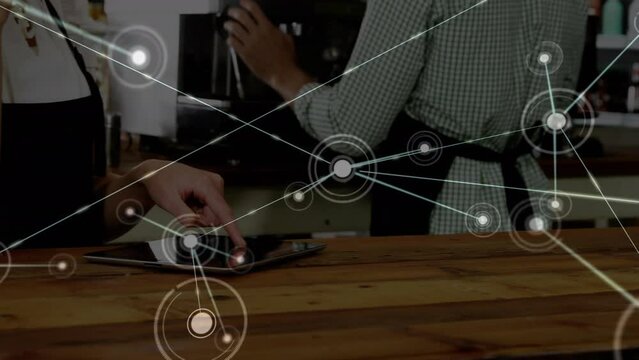Animation of network of connections against mid section of waitress using digital tablet at a cafe
