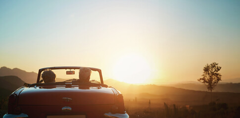 Fototapeta na wymiar Back, sunset and a senior couple on a road trip in a convertible car for travel, freedom or adventure together. Love, mockup or view of nature with an elderly man and woman in a vehicle for a drive