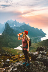 Woman drinking water with plastic reusable bottle in mountains Travel lifestyle adventure active...