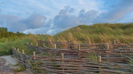 Fototapeta na wymiar coastal fortifications on the city beach. Dune fortification fence.