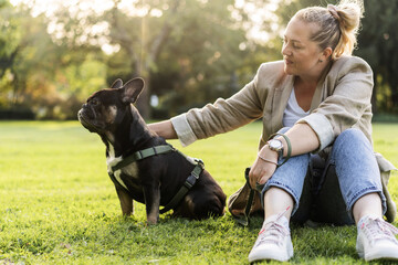 Blonde girl of forty years old cuddles with her dog