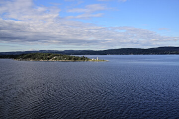 Wide angle view of the Oslofjord with forests and mountain landscape on the coast, with Sondre Langara Fog bell on Langara island, Norway