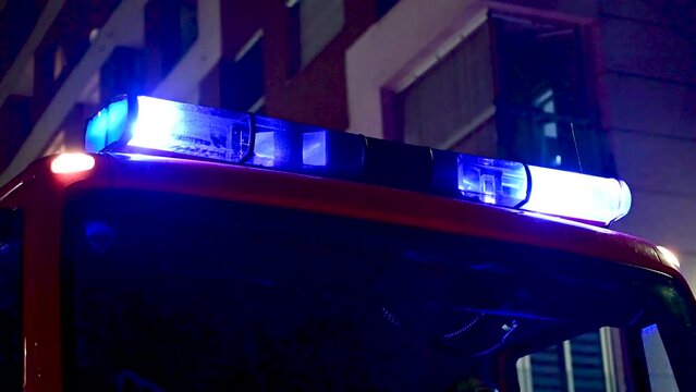 Firefighter emergency lights flash at night. Flashing blue lights on firefighter truck. Firefighters intervention.  